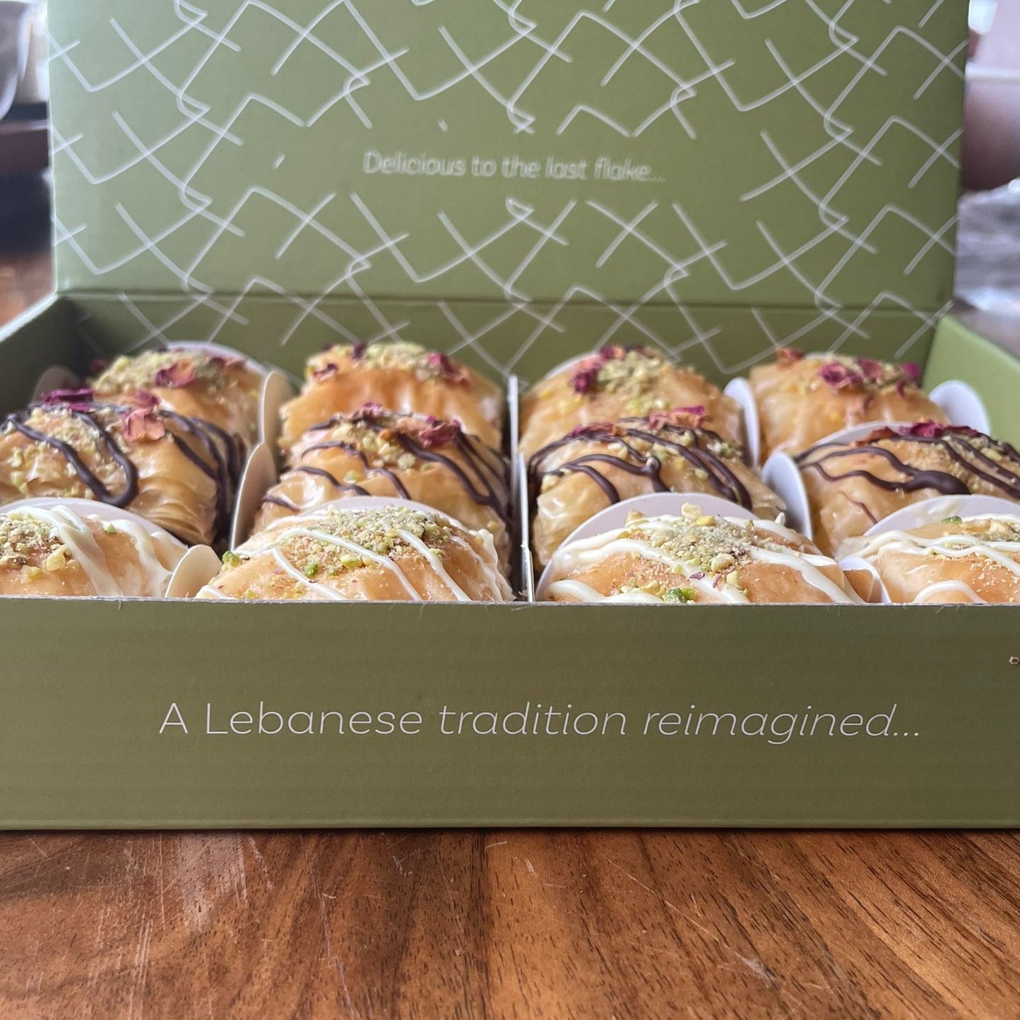 Box of mixed flavour baklawa on a wooden surface