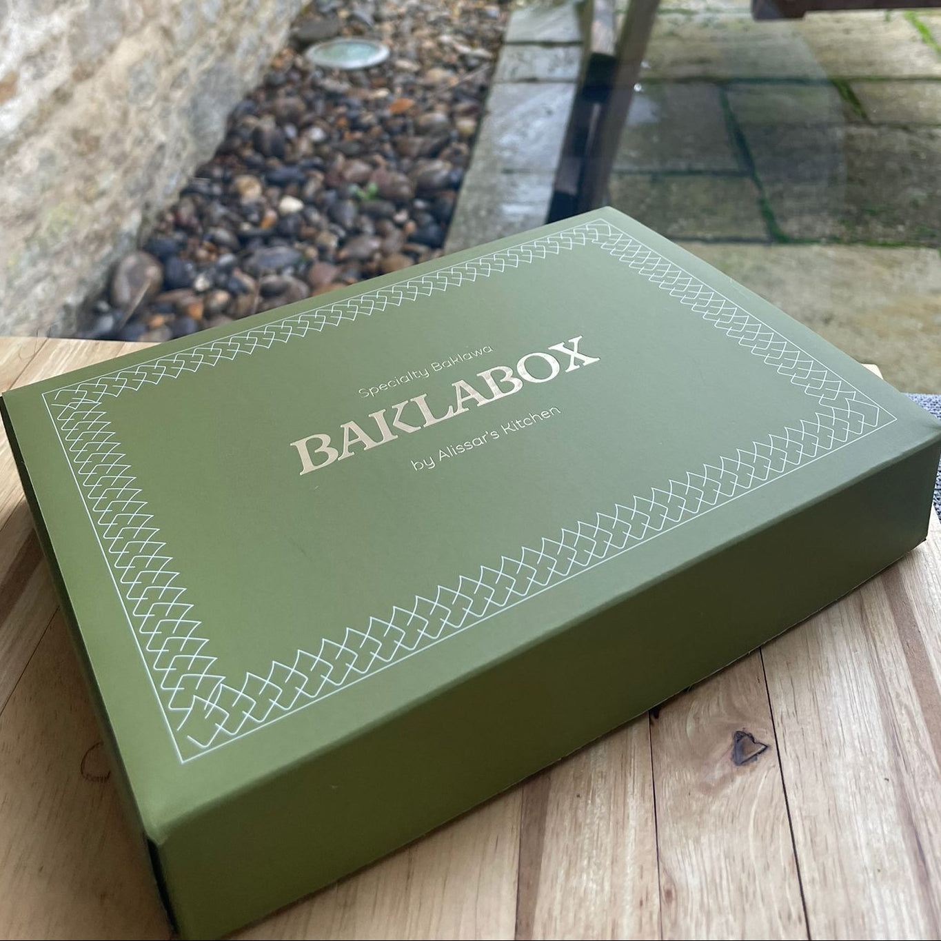 Green box with 'BAKLABOX' branding on a wooden surface
